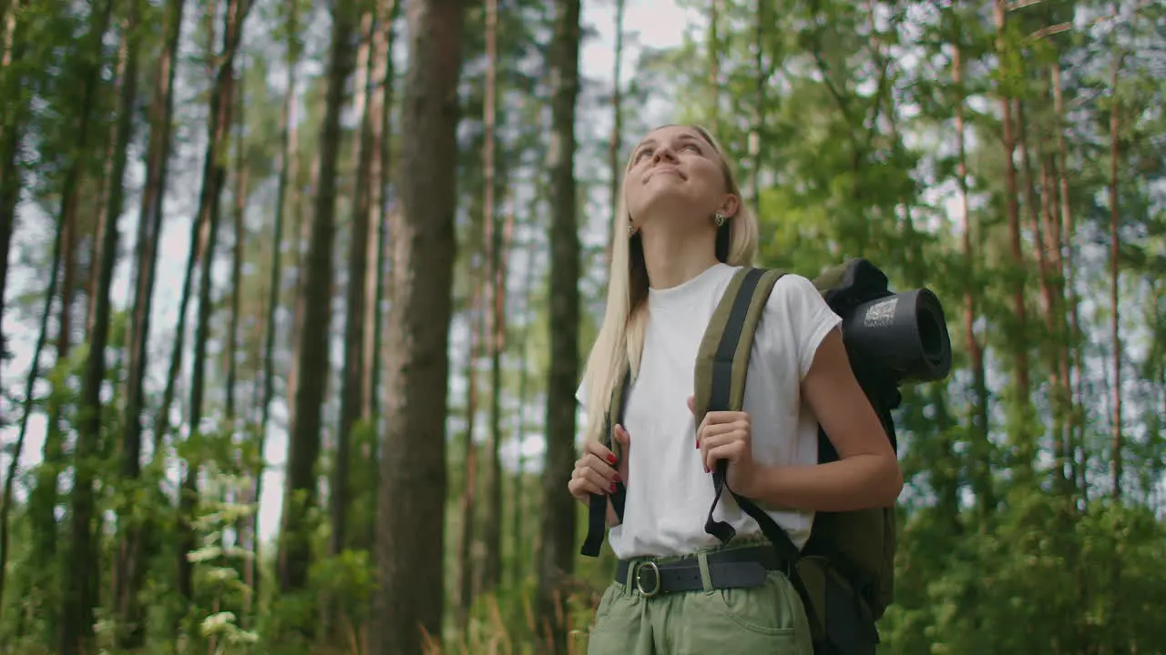 Slow motion Portrait Adult caucasian woman wearing shorts and t-shirt hikes through woods Young lady hiking