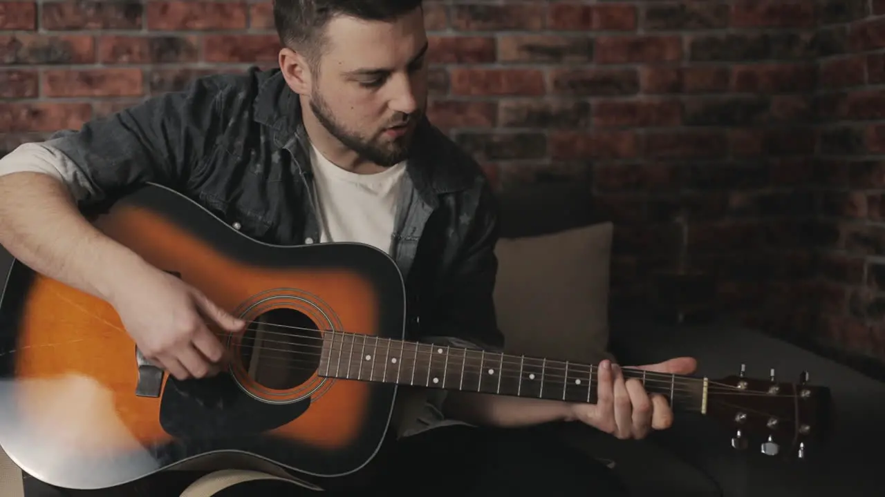 Young Musician Man Playing Guitar And Singing At Home