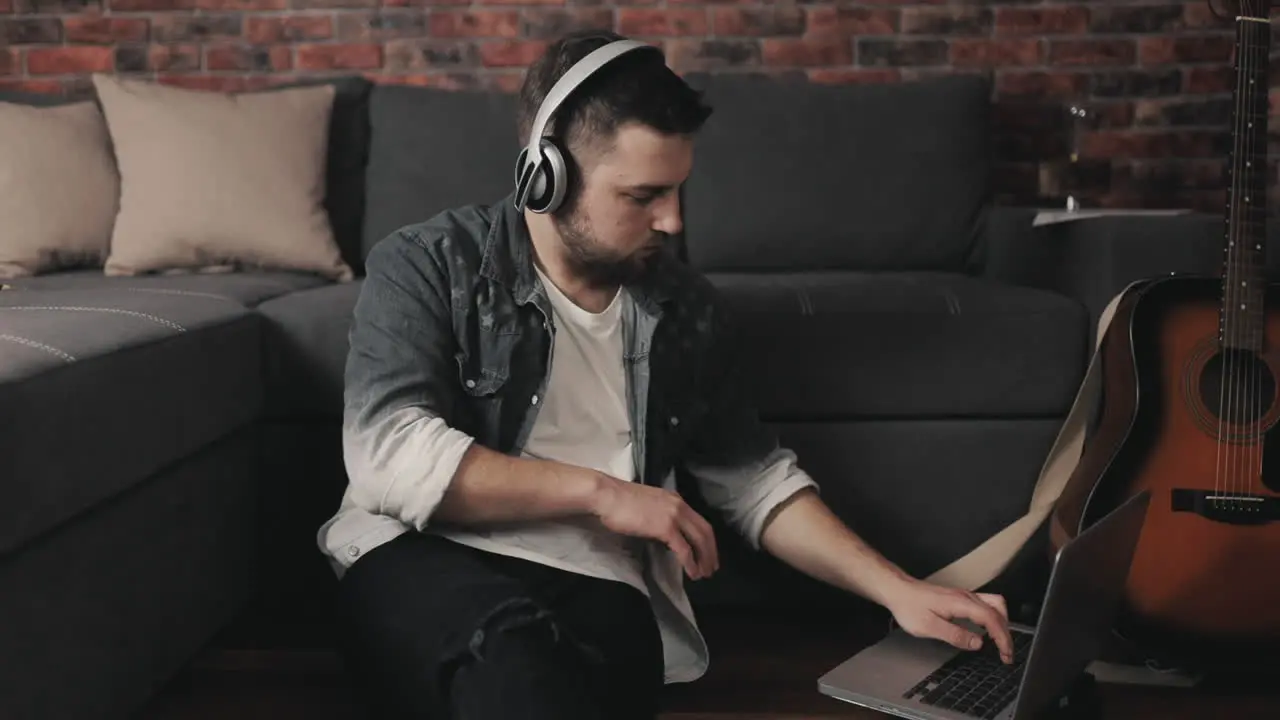 Young Musician Man Playing Guitar Singing And Using Laptop At Home