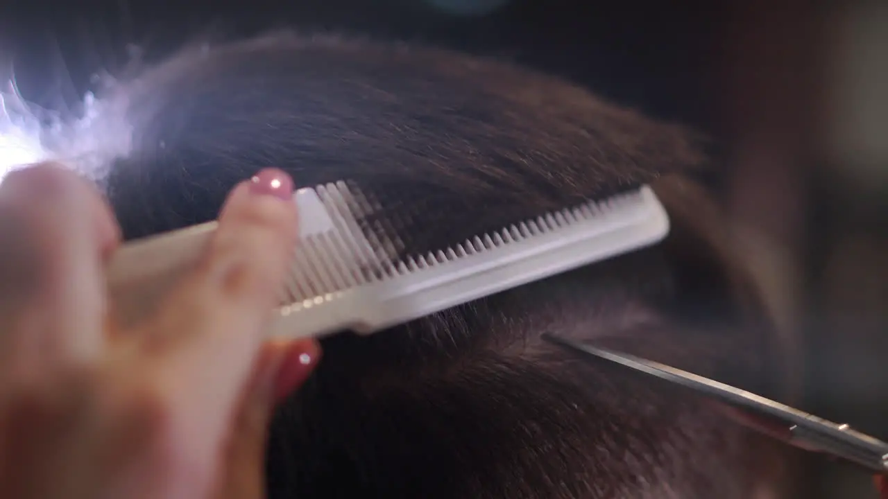 Close up of men's hair cutting scissors in a beauty salon Frame Close up of a haircut at a hair saloon Professional barber styling hair of his client