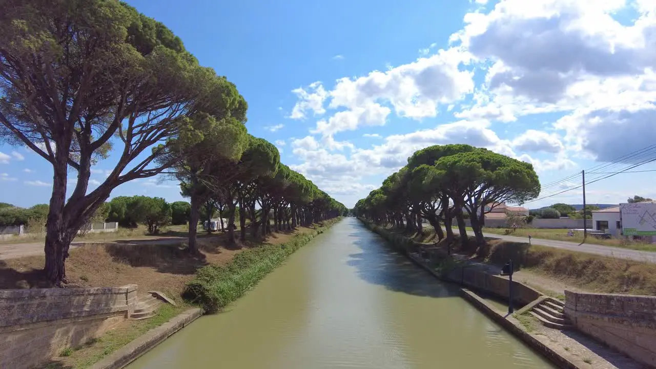 long canal between a grove of trees in the south of France