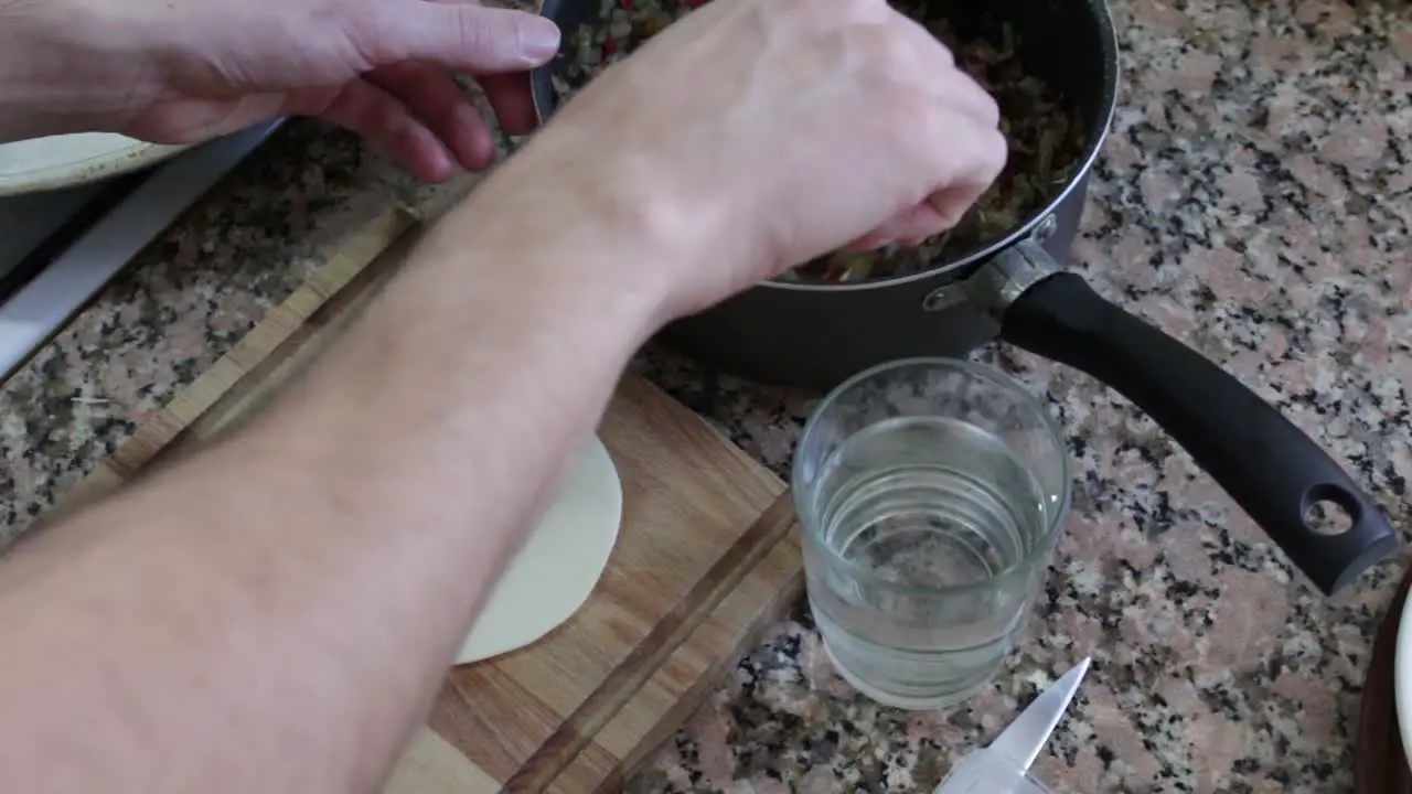 Static shot of hands stuffing an empanada