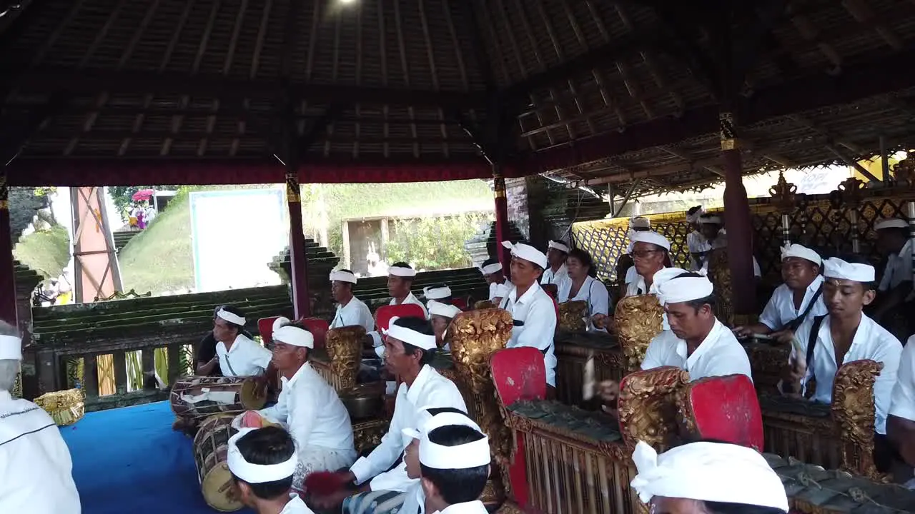 Large Orchestra Plays Gamelan Music at Hindu Religious Ceremony of Bali Indonesia wearing Traditional Outfits