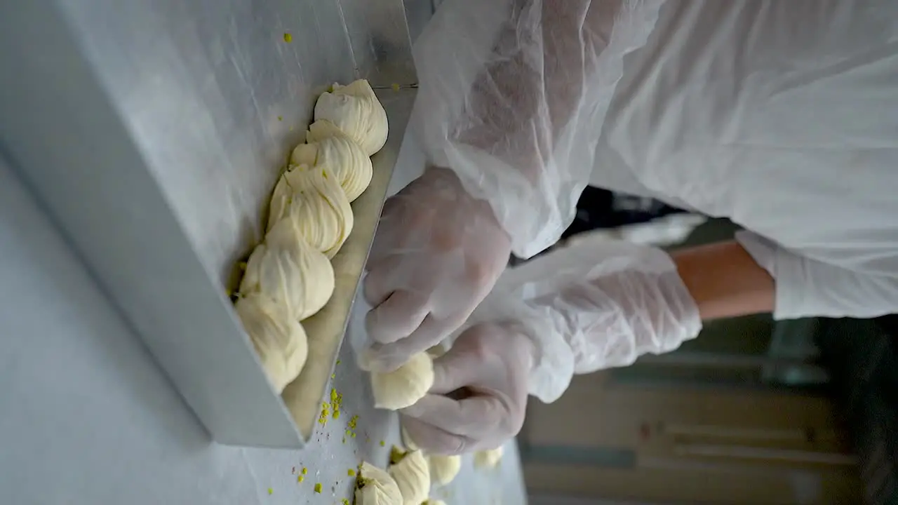 The Turkish pastry chef places pieces of oyster baklava in the tray