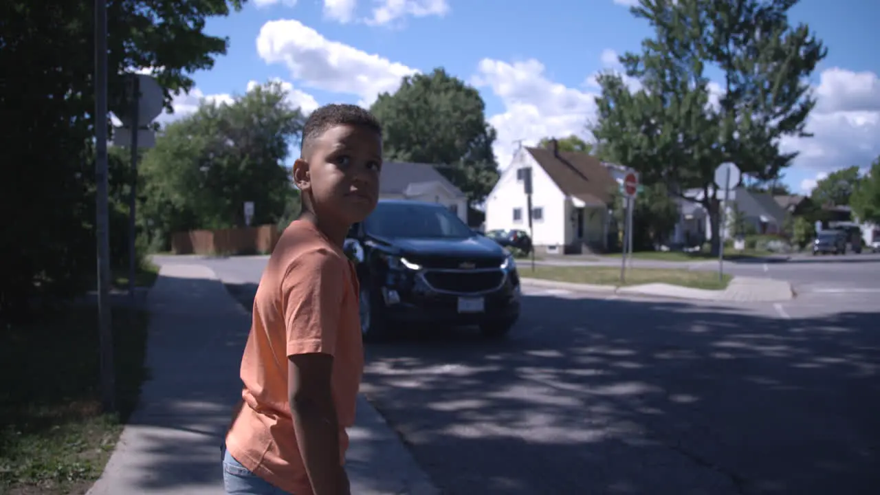 Young african american kid looks both ways before crossing the street