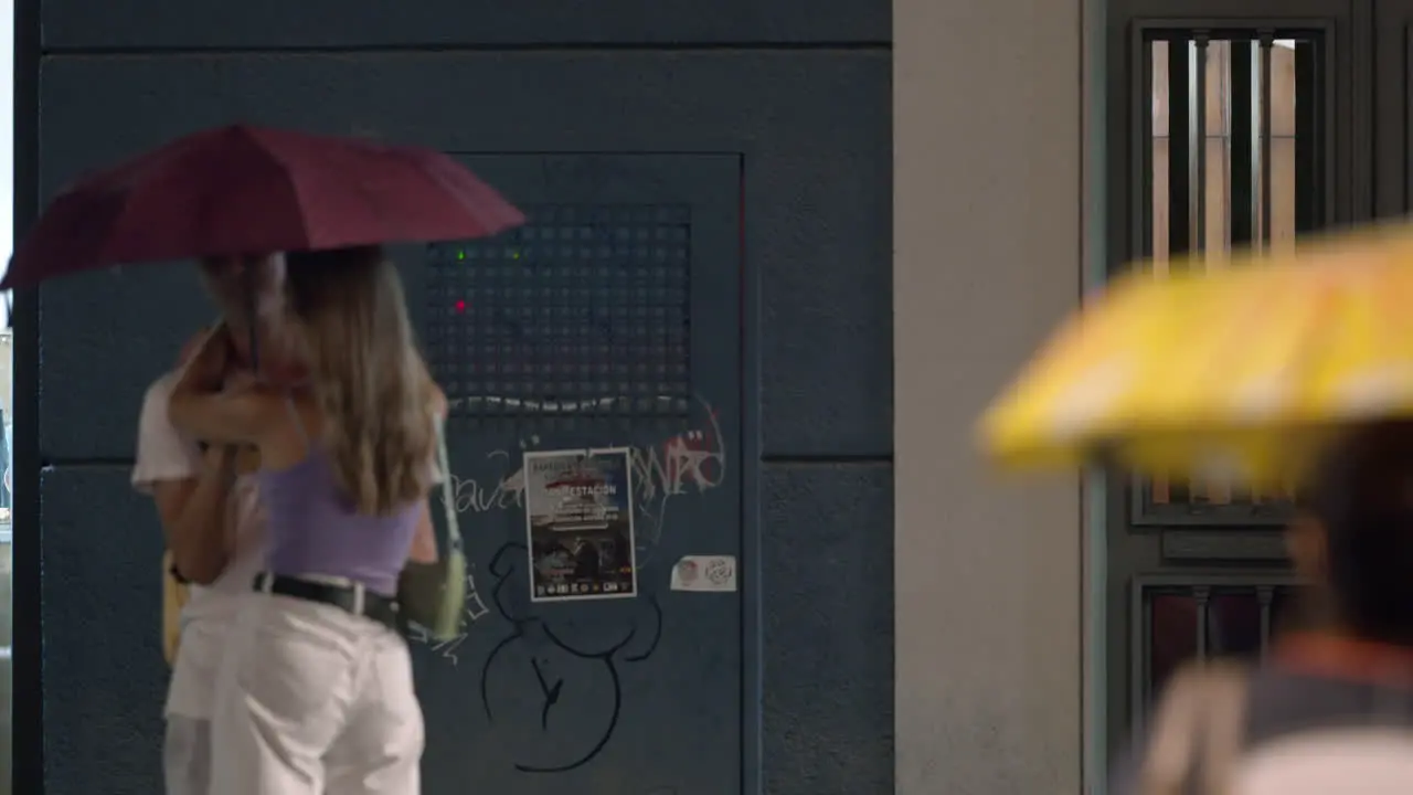 People with umbrellas in the evening city during rain