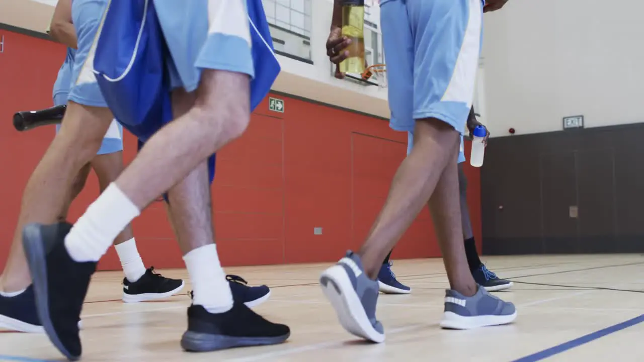 Diverse male basketball team training in indoor court in slow motion