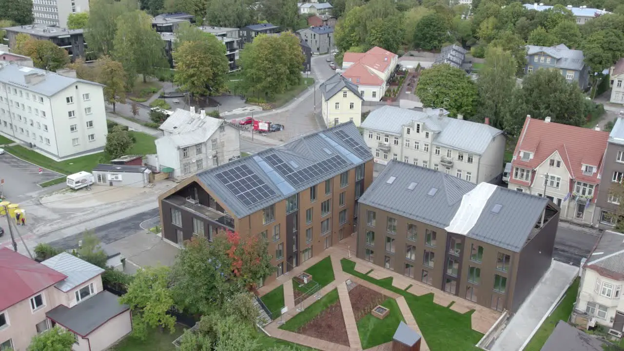 Drone flying over new apartment building Karlovakodu Lootuse 2 there is also Tartu public transportation red city bus driving by