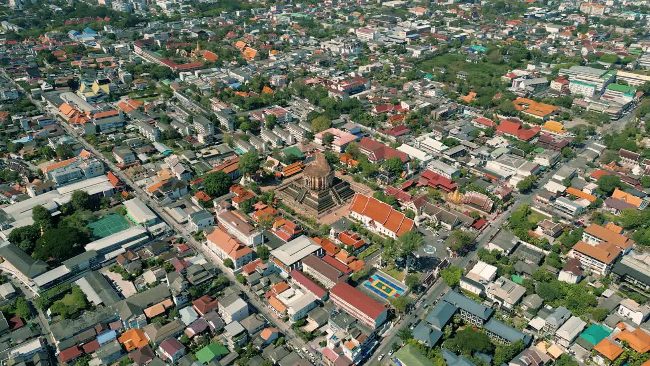 4K Cinematic urban drone footage of a panoramic aerial view of the temple of Wat Chedi Luang in the center of the city of Chiang Mai Thailand on a sunny day