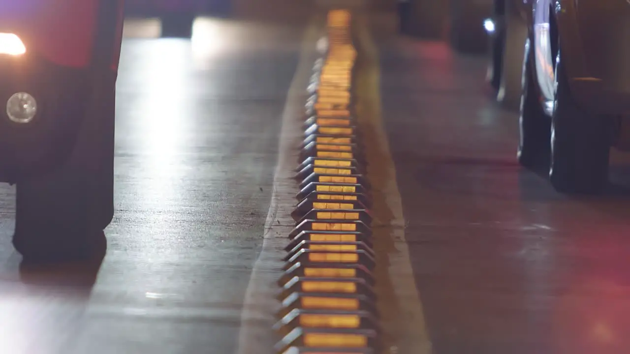 Telephoto view of a road as cars passing on a downtown city street at night