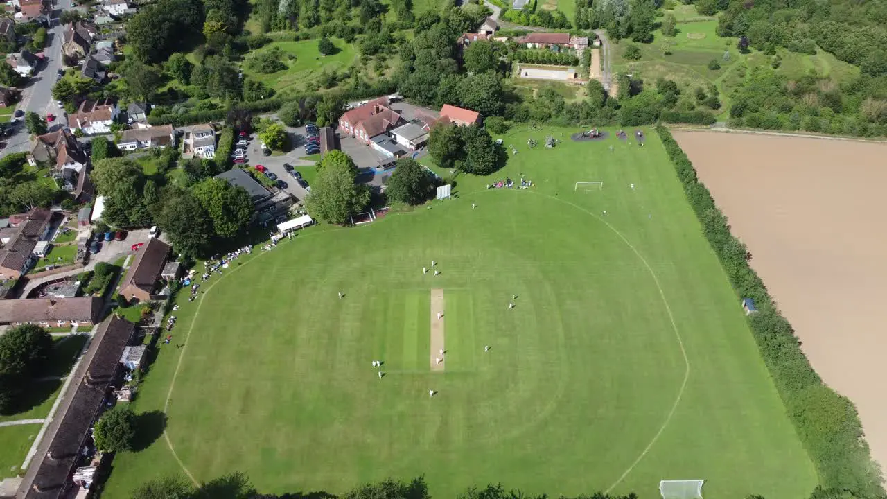 4K drone video flying towards a English village cricket match