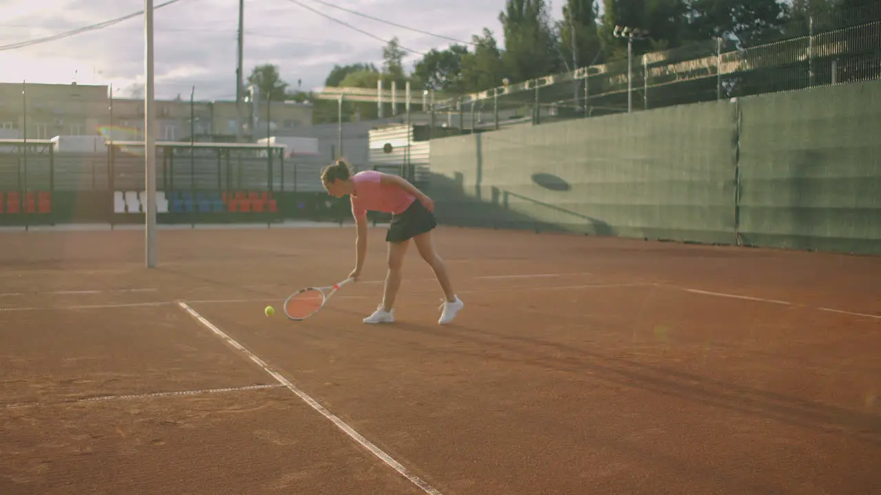 Attractive Athlete Poses Near Net In Tennis Court Young athletic female playing tennis walking in an indoor court woman player become on a game position training day