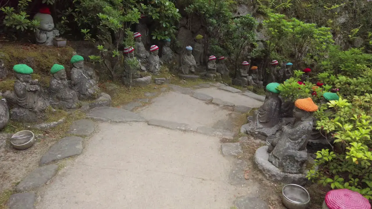 Small Buddha statues with woolly hat on a path of the Daisho-in Buddhist temple site on the on Miyajima Island prefecture of Hiroshima