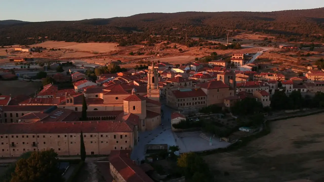 Aerial view of a monastery and the town to which it belongs at sunset