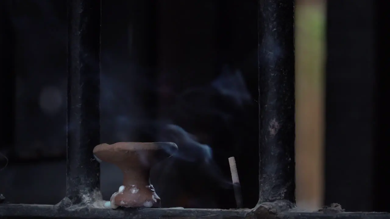 A stick of incense burning and giving off an aromatic smoke at a Hindu temple in the city of Kathmandu Nepal