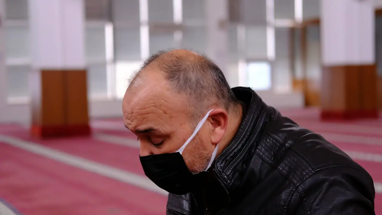 Old Man Masked Raising His Hands And Praying In Mosque 1