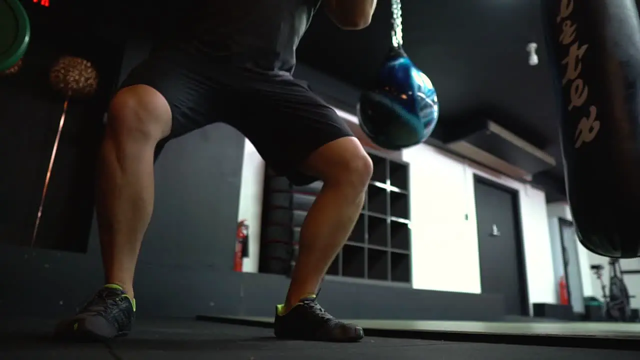 A trainer is using a medicine ball in side a gym