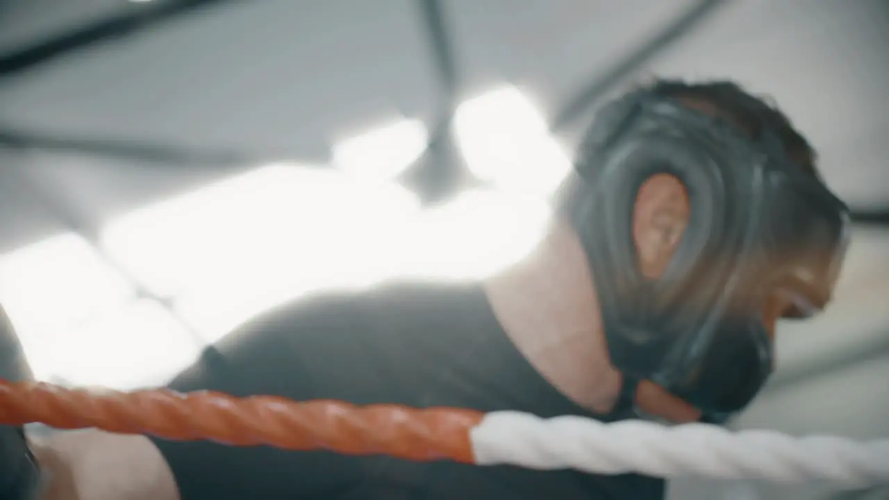 Tired Boxer Leaning on Ropes