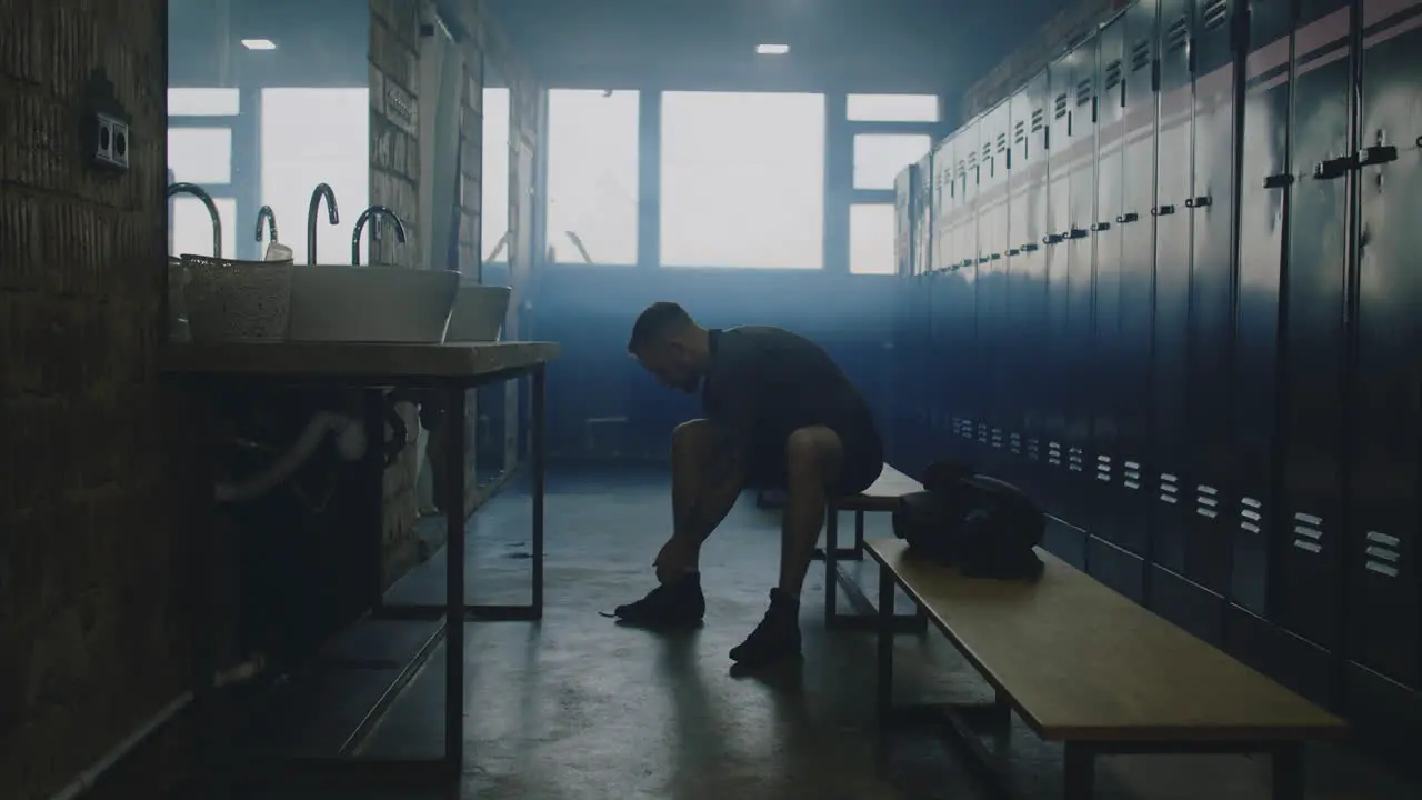 Man Tying Shoes in Locker Room