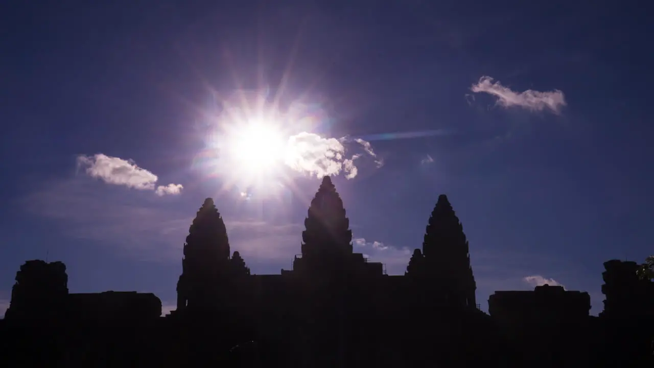 Angkor Wat silhouette wiht sun and isolated clouds