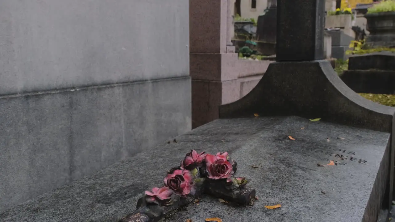 Beautiful crucifix on top of a grave a rainy day in pere lachaise cemetary