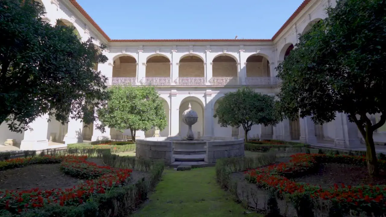 A cloister garden inside a Portuguese monastery called 'Santa Mafalda de Arouca Monastery ' featuring a stone monument  situated in Arouca