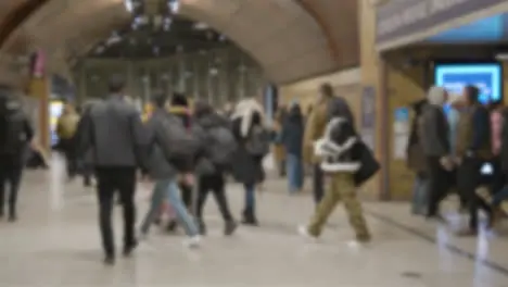 Defocused Shot Of Entrance To London Bridge Rail Station London UK With Commuters At Night 