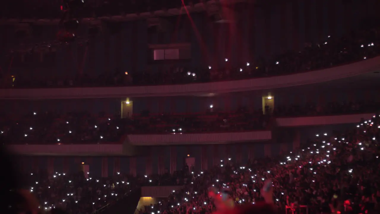 Fans at concert waving lanterns in the dark