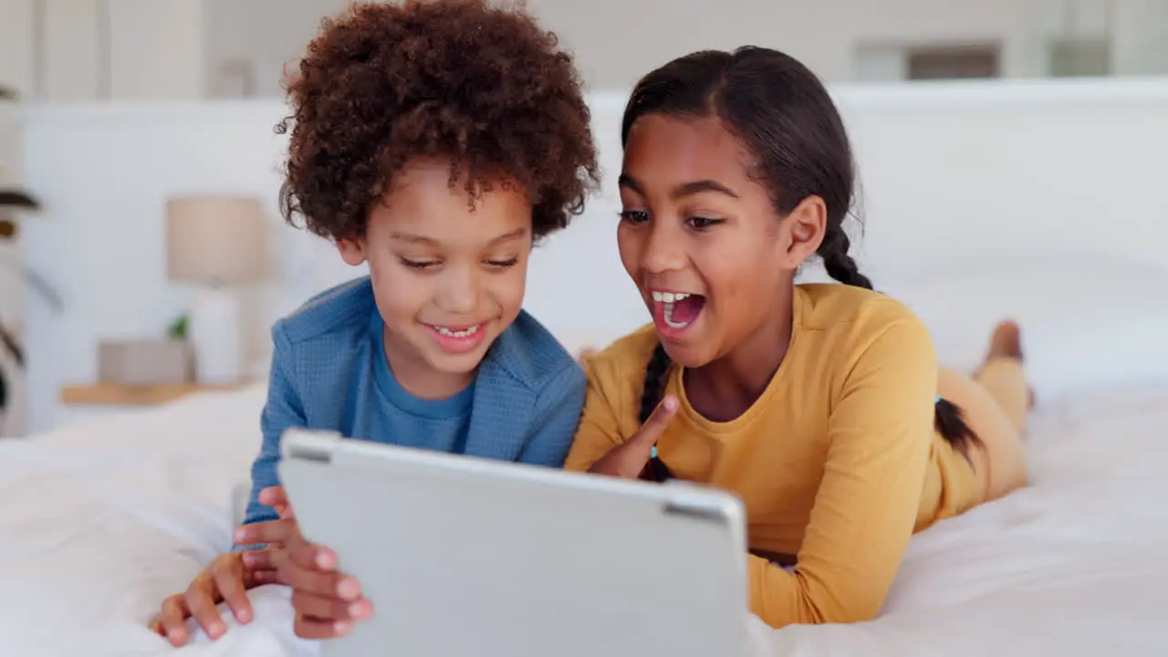 Happy children and tablet on a bed for siblings