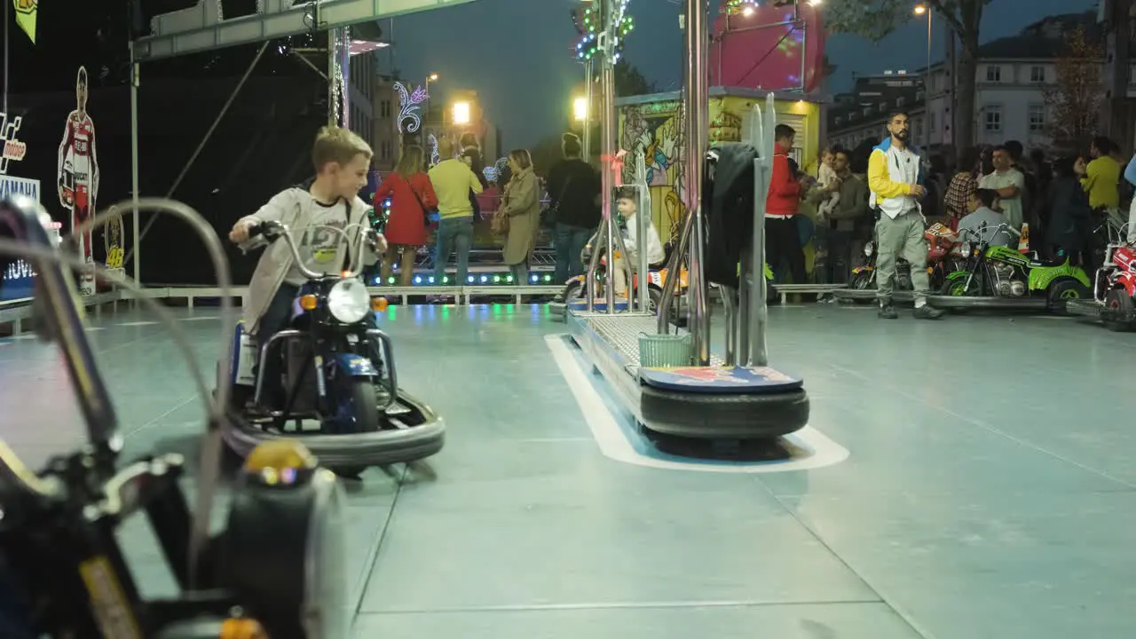 Establishing shot Young kids ride Bumper cars playground at San Froilán Festival Lugo