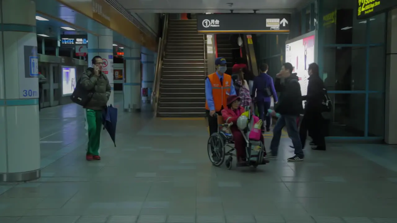 Walking Asian commutors and disabled person in wheelchair changing plattform