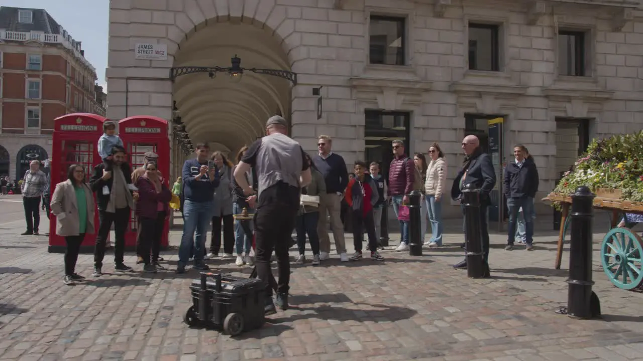 Street Performer In Covent Garden Market With Tourists In London UK