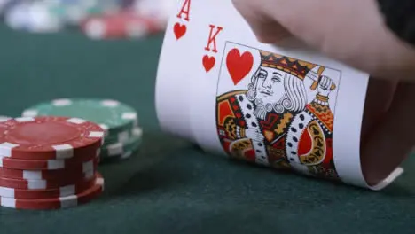 Extreme Close Up Shot of Poker Player Looking at Ace King Suited