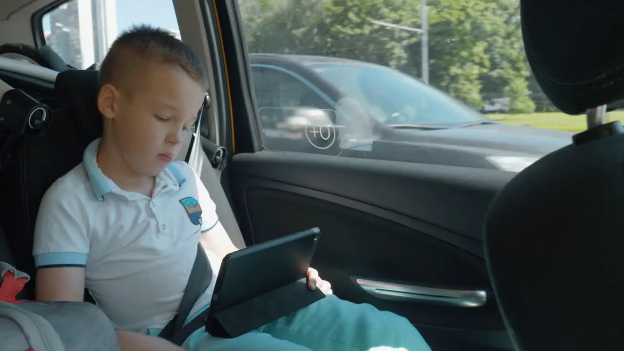 Bored child watching movie on pad during car ride