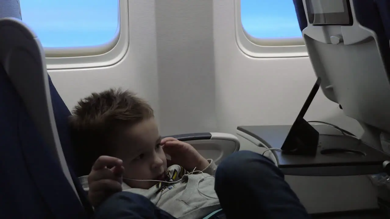 Child entertaining with mobile phone in the plane