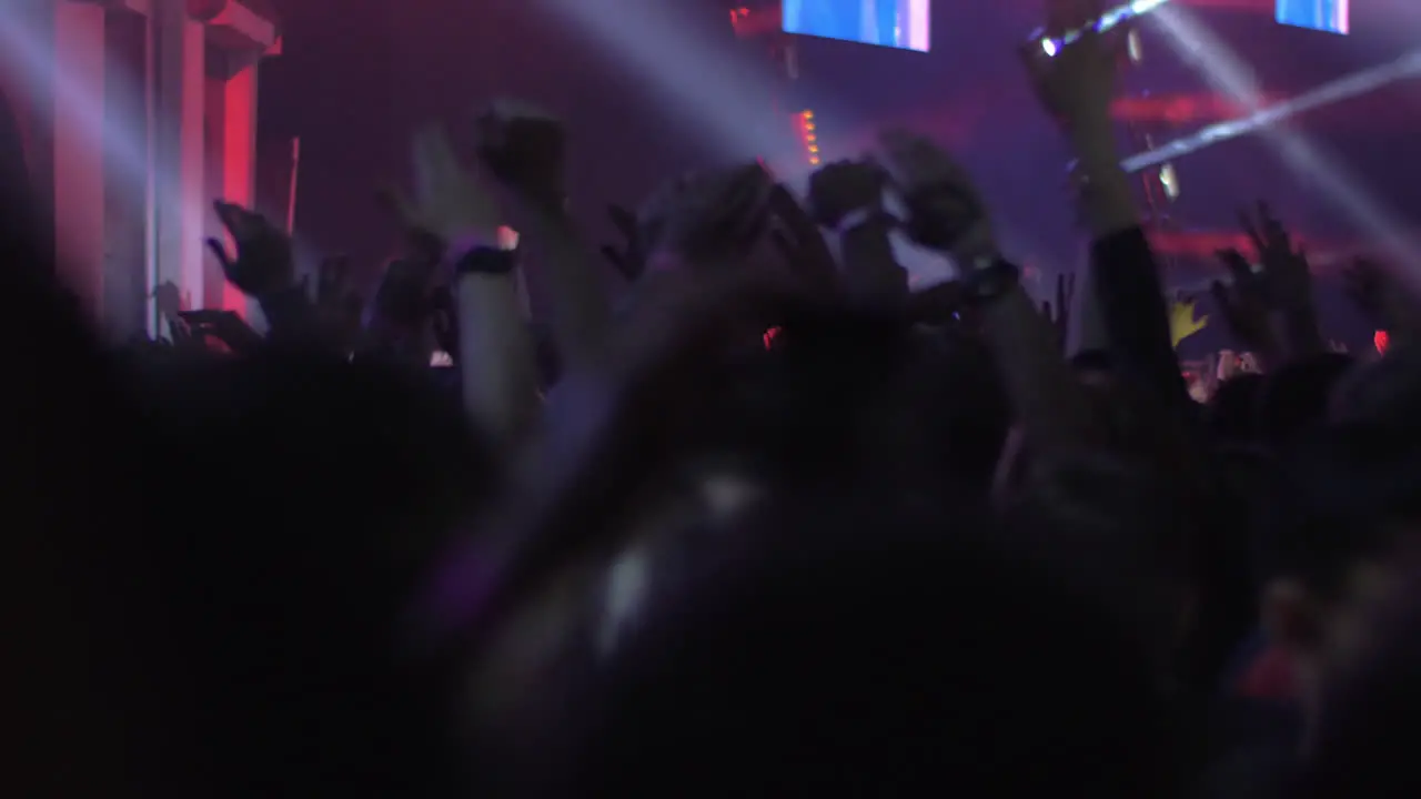 Crowd of excited music fans with hands up at the concert