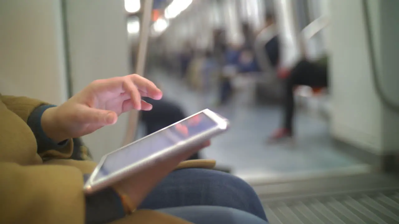 Woman in subway train using tablet PC