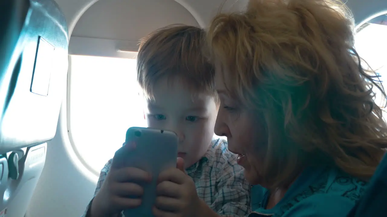 Grandmother and grandson with cell in the plane