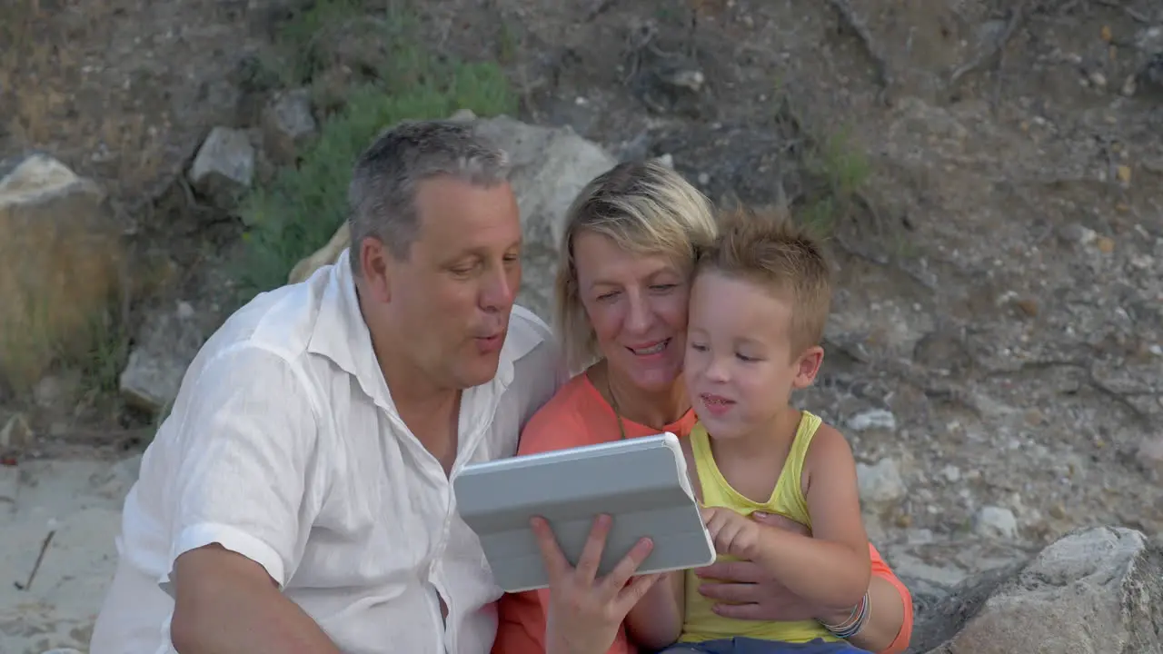 Grandparents and grandchild with pad outdoor