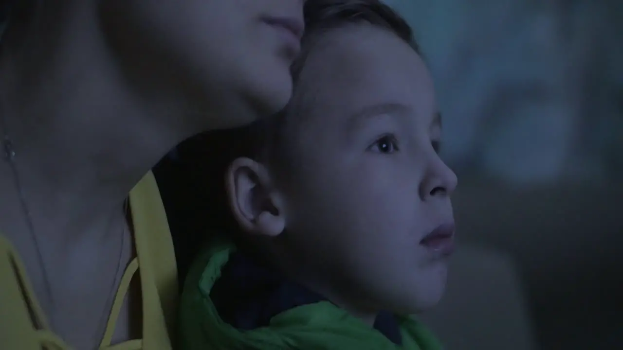 Mom and child watching film at the cinema