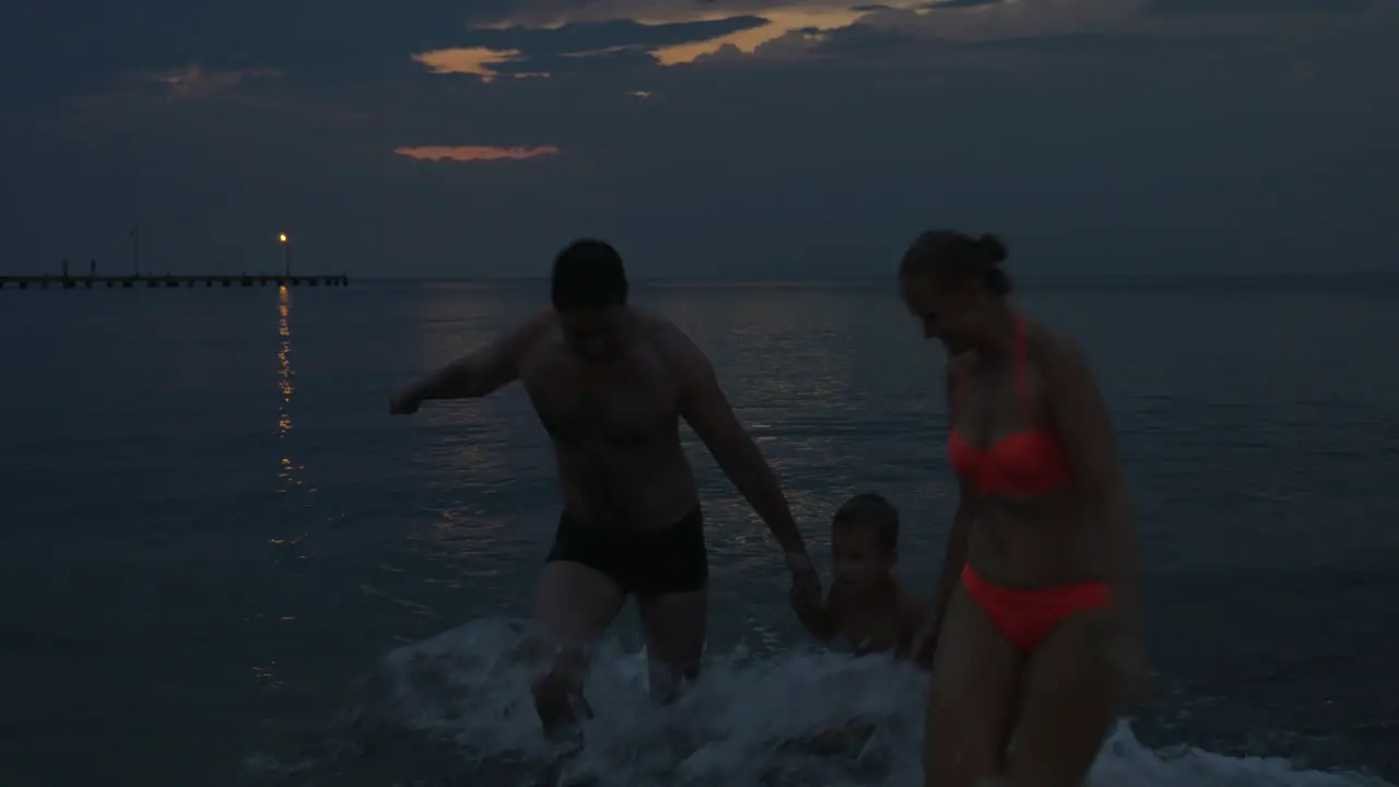 Family are swimming in the sea after sunset Piraeus Greece