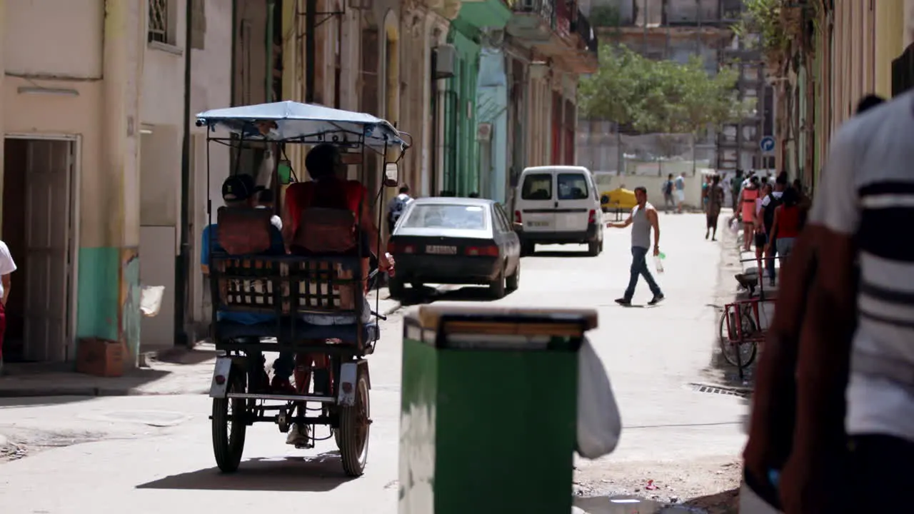 Rear View Of Tricycle Riding Past In Street In Cuba On Sunny Day