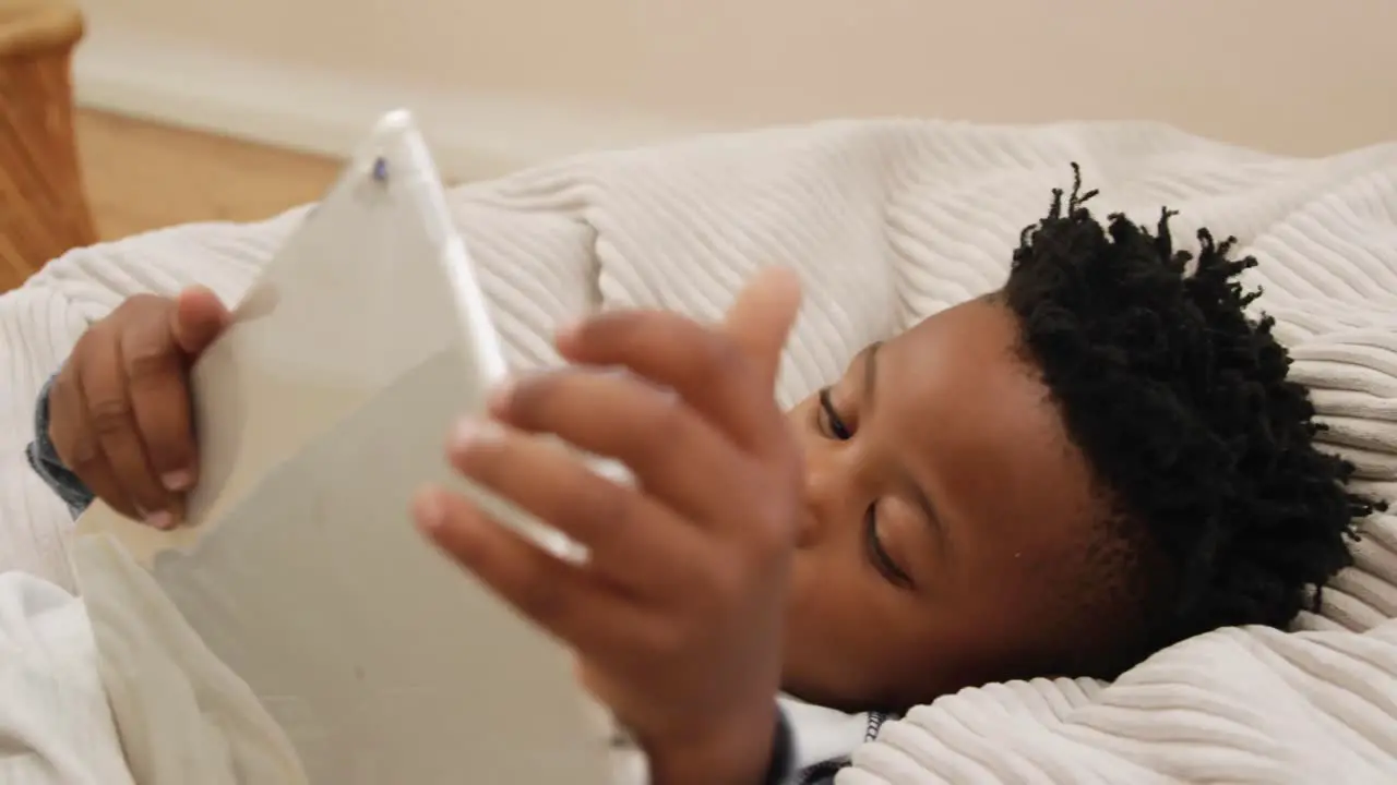 Boy using tablet computer at home