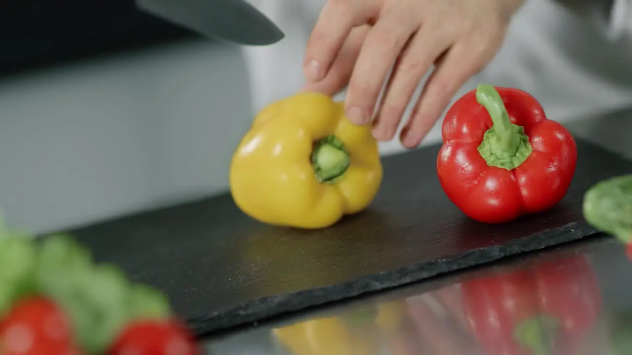 Chef cooking food at kitchen restaurant Closeup chef hands slice yellow pepper