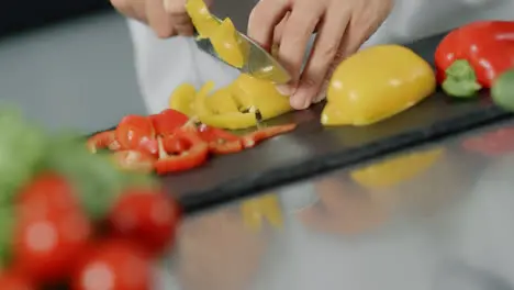 Male chef cooking fresh food at kitchen restaurant Closeup hands slicing pepper