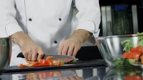 Chef cooking vegetables at kitchen Closeup hands cutting organic food