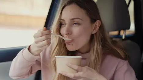 Woman having her meal inside the parked car slow mo