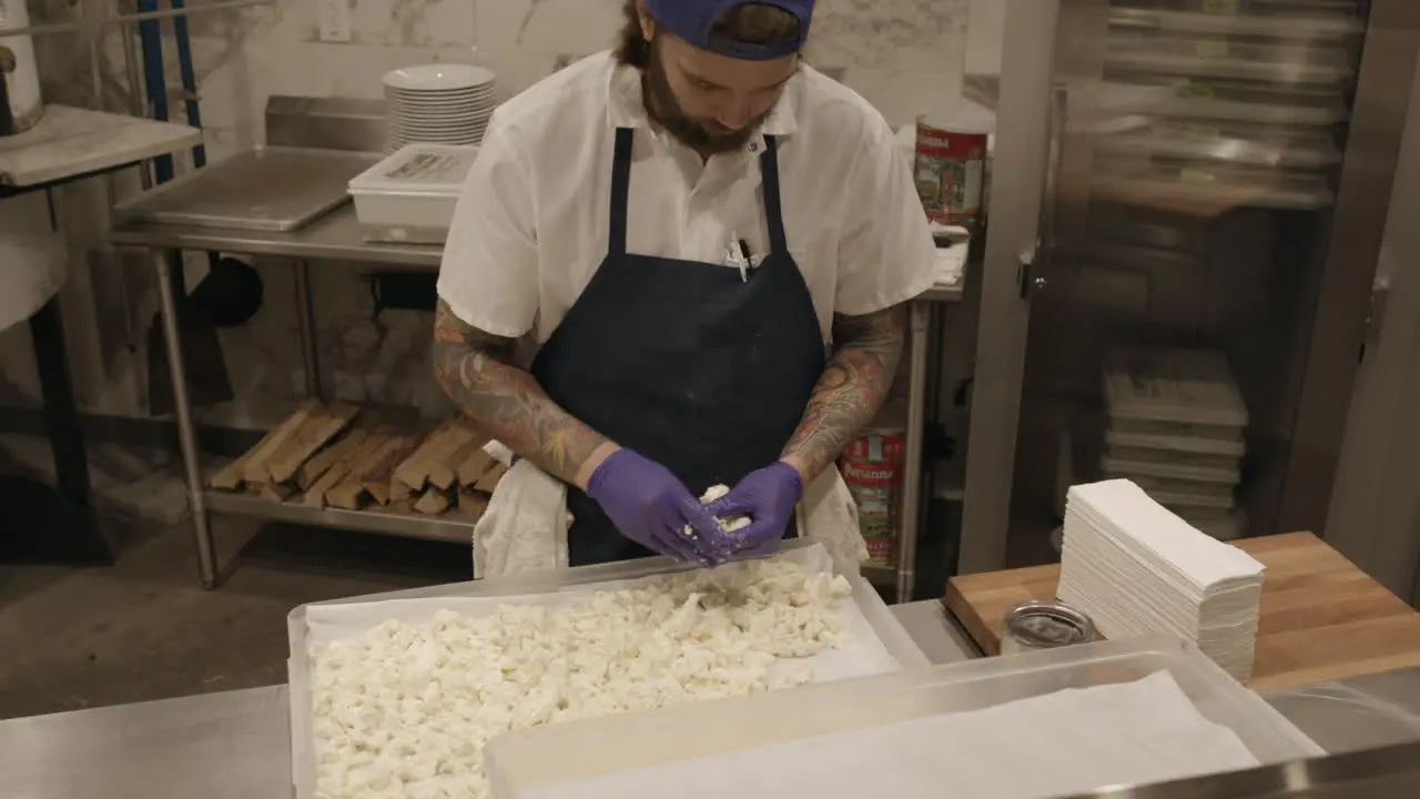 A pizza chef prepares dough in a pizza kitchen of a stylish upscale restaurant