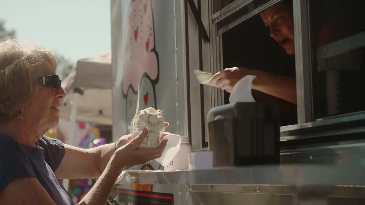 Middle-Aged woman buying ice cream bowl from street vendor