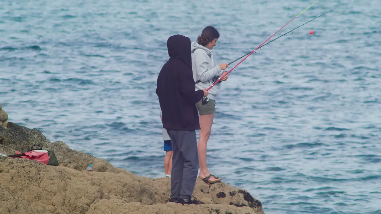 Single Mom With Her Family Doing Some Fishing Activity In The Placid Beach Of Porthallow Cornwall England UK